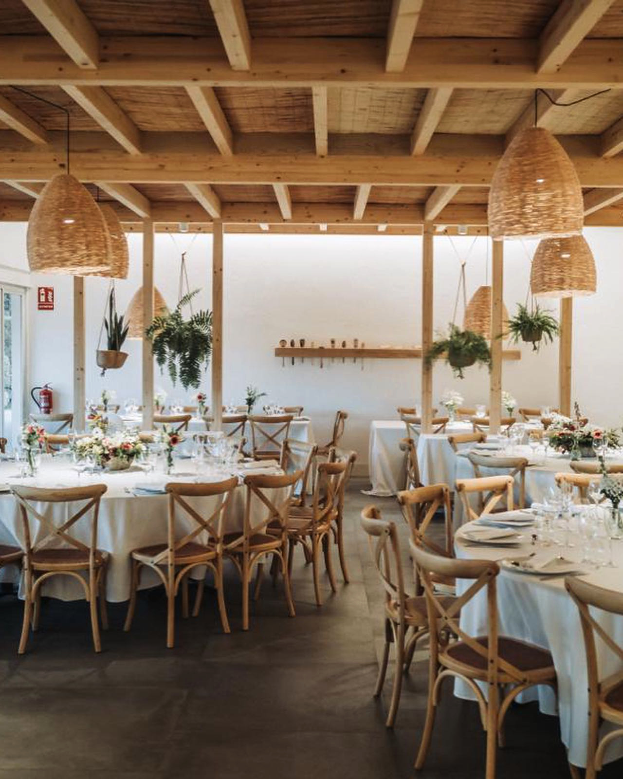 Interiorisme per a restaurants: com crear espais que funcionin i emocionin 6 Un restaurant mediterrani amb llum càlida, fusta natural i plantes interiors, to suau i acollidor, estil arquitectònic modern però proper.